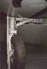 Starboard main gear, viewed from ahead, looking aft. Lowered flap in background.